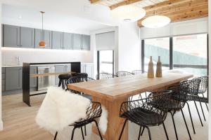 a kitchen and dining room with a wooden table and chairs at Inuit by FeelFree Rentals in Vielha