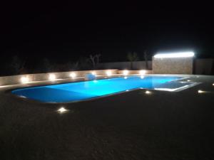 a swimming pool lit up at night with lights at Gli Ulivi Residence in Leverano