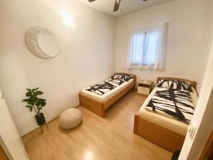 2 camas en una habitación pequeña con espejo en ELA i GABI en Omišalj