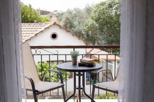 a table and two chairs on a balcony at The Island Life Apartments by Konnect, Ipsos Beach in Ipsos