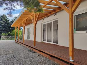 una terraza de madera en el lateral de una casa en Friends & Family Apartmanok Velence en Velence