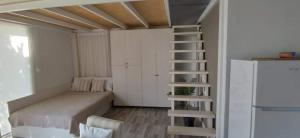 a small bedroom with a bed and a refrigerator at Alos in Ammouliani