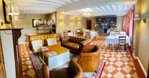a living room with leather furniture and a dining room at Auberge d'Inxent in Inxent