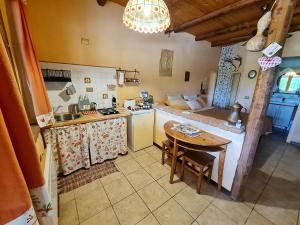 a kitchen with a table and a kitchen with a couch at Cascina Beneficio in Castelnuovo Bormida