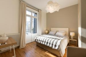 ein Schlafzimmer mit einem Bett und einem großen Fenster in der Unterkunft Villa Jules Simon in Saint-Malo