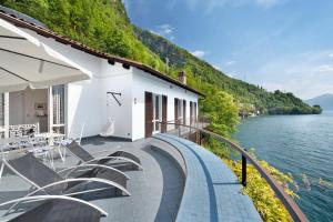a building with stairs next to a body of water at Villa Vittoria in Varenna