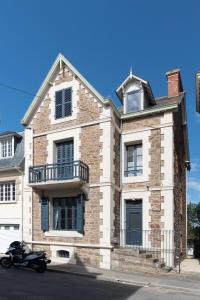 una motocicleta estacionada frente a una casa de ladrillo en Villa Jules Simon, en Saint-Malo