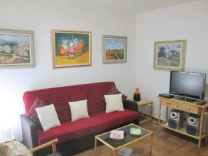 ein Wohnzimmer mit einem roten Sofa und einem Flachbild-TV in der Unterkunft apartamento 5 estrellas fanals in Lloret de Mar