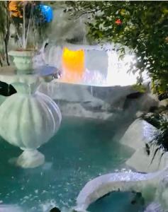 une fontaine dans un jardin avec une piscine d'eau dans l'établissement Бутик-отель Белый Дом Балерины, à Soukhoumi