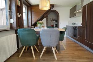 cocina con mesa de madera y sillas verdes en Kandel - Stubenhof, Black Forest, en Simonswald