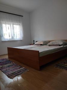 a large bed in a bedroom with two pillows on it at Apartments Pasta in Poljica