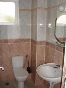 a bathroom with a toilet and a sink and a mirror at Hotel Panorama in Sveti Vlas