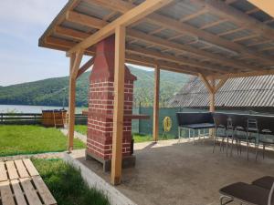 d'une terrasse avec une cheminée, une table et des chaises. dans l'établissement Entire Chalet, Amazing Panoramic View of Calinesti Oas Lake, à Călineşti-Oaş