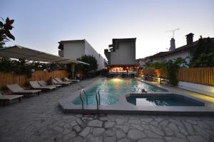 a large swimming pool with chairs and a building at Anna Christina Apartments in Metamorfosi