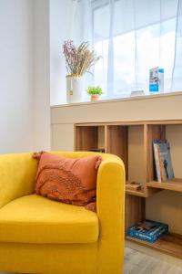 a yellow couch sitting in a room with a window at Le Krisco, une maisonnette en cœur de ville avec un parking privé in Vannes