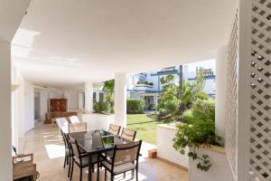 a dining room and living room with a table and chairs at VIP Dominion Beach Estepona in Estepona
