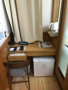 a desk in a room with a chair and a desk with a phone at Business Hotel Crescent in Tokyo