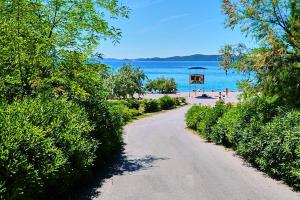 uma estrada de terra que leva a uma praia com pessoas nela em Apartment Luan em Zadar