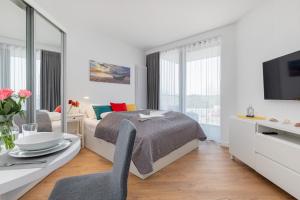 a bedroom with a bed and a table with a chair at Apartments Mazowiecka by the Sea Pobierowo by Renters in Pobierowo