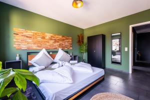 Bett in einem Zimmer mit grünen Wänden in der Unterkunft Studio Fayence - EMMA, Netflix, WiFi, Workspace in Karlsruhe