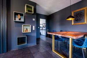 uma sala de jantar com paredes azuis e uma mesa de madeira e cadeiras azuis em Studio Fayence - EMMA, Netflix, WiFi, Workspace em Karlsruhe