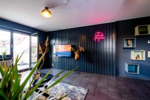 卡尔斯鲁厄Studio Fayence - EMMA, Netflix, WiFi, Workspace的一间拥有蓝色墙壁和墙上 ⁇ 虹灯标志的房间