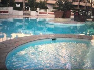 a large swimming pool with blue water in it at VILLA MAUPASSANT T2 BORD DE MER in Cannes