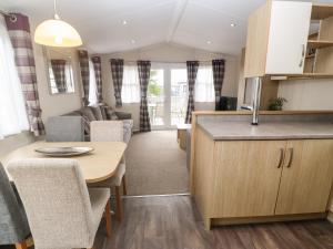 a kitchen and living room in a caravan with a table and chairs at Brockenhurst in Redruth