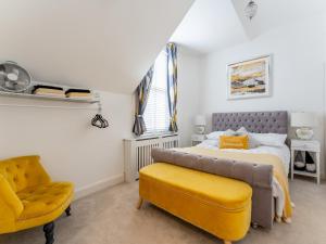 a bedroom with a bed and a chair at Pass the Keys Gorgeous 2 bedroom flat in Penn Hill in Poole