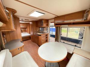 a kitchen and dining area of an rv with a table at Your Camp Hel in Hel