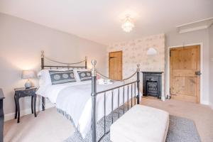 ein Schlafzimmer mit großem Bett und Kamin in der Unterkunft Coachman's Cottage, Wrentham in Beccles