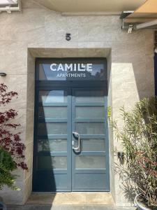 budynek z niebieskimi drzwiami z napisem w obiekcie Camille Apartmanhouse w Budapeszcie