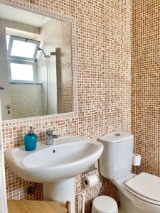 uma casa de banho com um lavatório, um WC e um espelho. em Pirata hostel Milfontes em Vila Nova de Milfontes