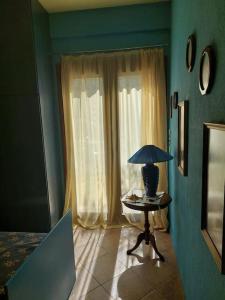 ein blaues Zimmer mit einem Tisch mit einer Lampe in der Unterkunft Bill's Garden Villa in Kalamos
