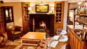 a living room with a fireplace and a couch and a table at Auberge d'Inxent in Inxent