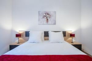 a bedroom with a white bed with two lamps at Le Bois Gentil - Grand appartement familial, proche de Genève et du Palexpo in Saint-Julien-en-Genevois