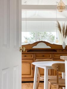 a kitchen with a white table and a window at Ragnar Glamp Milzkalne Lux in Rauda