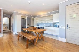 a kitchen with a wooden table and chairs and a counter at Deluxe Family Suite 105 in Knysna