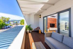 a balcony with a couch and a living room at Deluxe Family Suite 105 in Knysna
