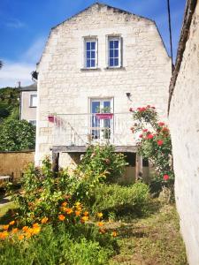 Casa de piedra con balcón y flores en Maison au calme avec terrasse et jardin, en Chinon