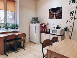 a kitchen with a refrigerator and a table and a microwave at У Поттера in Ternopil