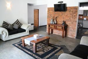 a living room with a couch and a coffee table at Arotin Game Lodge in Brits