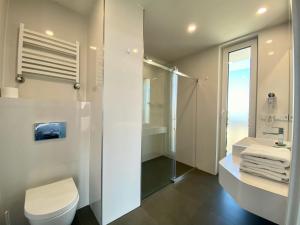 a bathroom with a shower and a toilet and a sink at Ferry Resort in Mielno