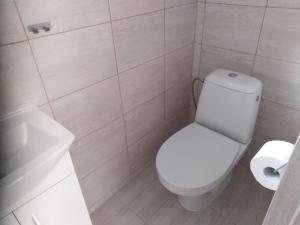 a white bathroom with a toilet and a sink at Bungalov Elite in Staré Splavy
