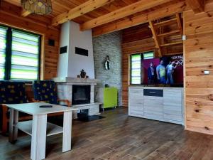 a living room with a table and a fireplace at Pod Jastrzębiem Chańcza in Chańcza
