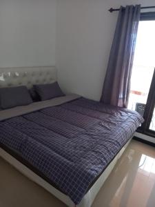 a bed with a blue comforter and a window at ARDMORE A10 HOMESTAY MALANG in Malang +17 photos
