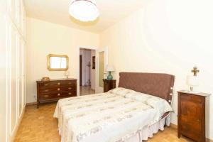 Schlafzimmer mit einem Bett, einer Kommode und einem Spiegel in der Unterkunft Appartamento Turati 74 in Turin