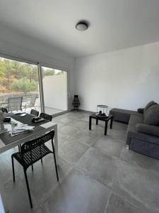 Rock N Sun - Brand new apartment in Ermioni في إرميوني: غرفة معيشة مع أريكة وطاولة