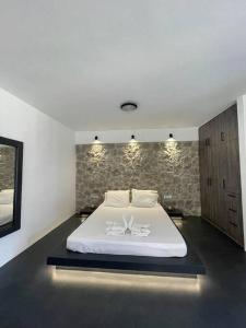 a bedroom with a white bed in a room at Rock N Sun - Brand new apartment in Ermioni in Ermioni