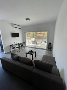 a living room with a couch and a table at Rock N Sun - Brand new apartment in Ermioni in Ermioni
